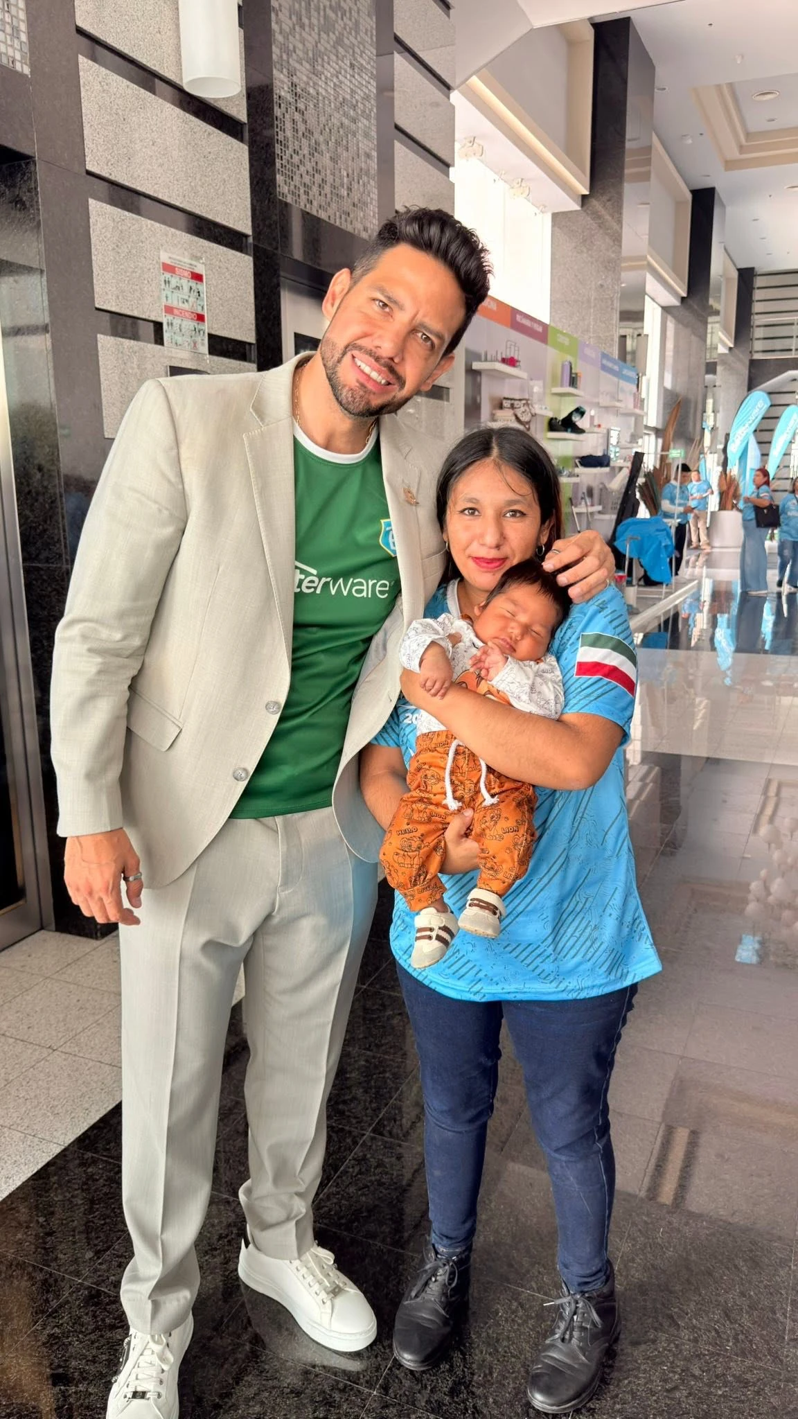 Rodolfo posa con una asistente y un bebé.