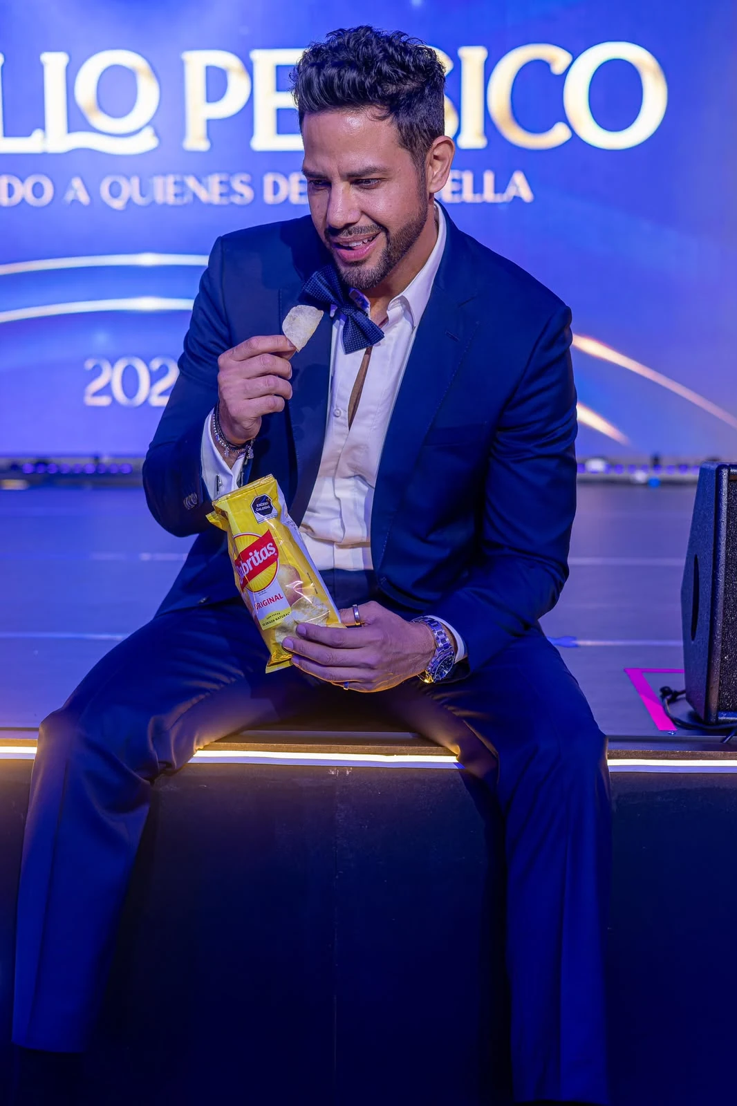 Rodolfo sentado con micrófono durante un evento de PepsiCo.